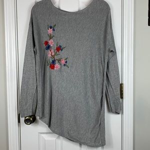 Liz Claiborne grey long sleeved sweater with bottom cut at an angle. Flowers med